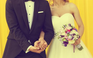 Gelin ve damat sarı bir arka plan üzerinde