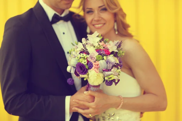 Menyasszony és a vőlegény a sárga háttér — Stock Fotó