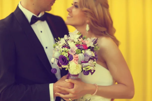 Bruden och brudgummen på gul bakgrund — Stockfoto