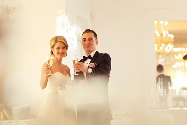 Bruid en bruidegom houden champagneglazen — Stockfoto