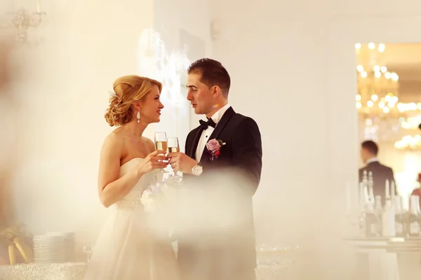 Bruid en bruidegom houden champagneglazen — Stockfoto