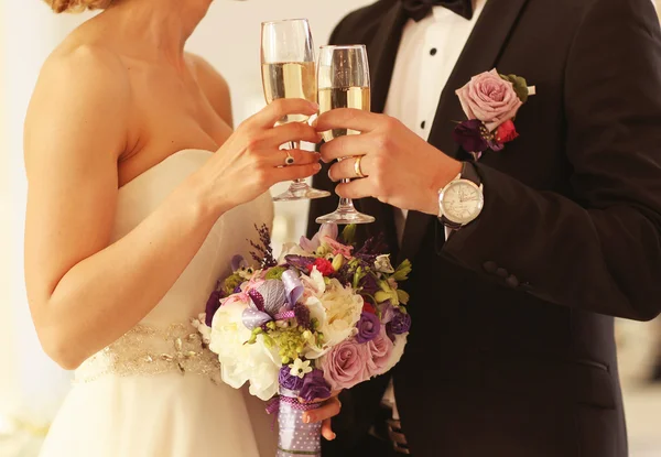 Bruden och brudgummen håller champagneglas — Stockfoto