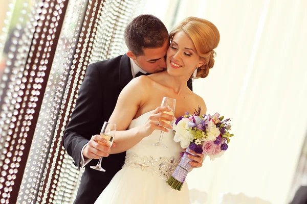 Bruid en bruidegom met een glas champagne — Stockfoto