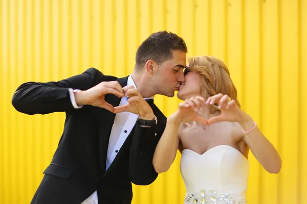 Bruid en bruidegom op een gele achtergrond — Stockfoto