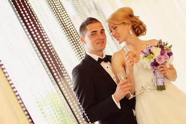 Bruid en bruidegom met een glas champagne — Stockfoto