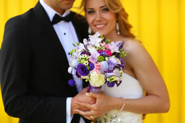 Bruden och brudgummen på gul bakgrund — Stockfoto