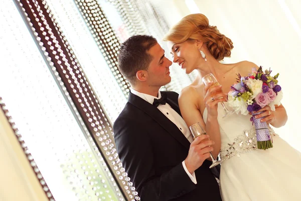 Bride and groom holding glasses of champagne — Stock Photo, Image