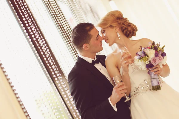 Bride and groom holding glasses of champagne — Stock Photo, Image