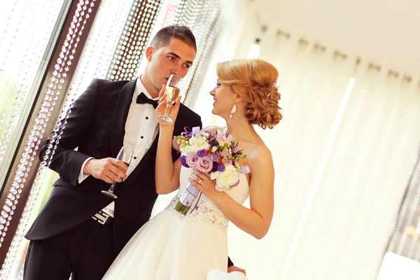 Bride and groom holding glasses of champagne — Stock Photo, Image