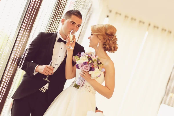 Bruid en bruidegom met een glas champagne — Stockfoto