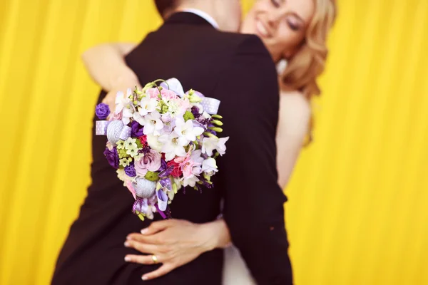 Bruid en bruidegom op een gele achtergrond — Stockfoto