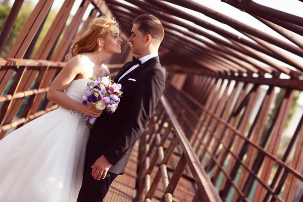 Bruid en bruidegom op een brug — Stockfoto