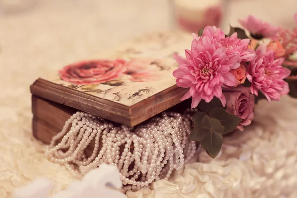 Wooden box with pearls and flower on a wedding table — Stock Photo, Image