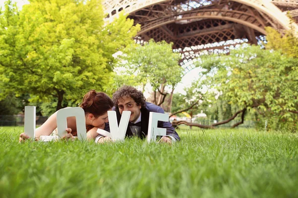 Mariée et marié tenant des lettres I DO dans leur main près de la tour Eiffel — Photo