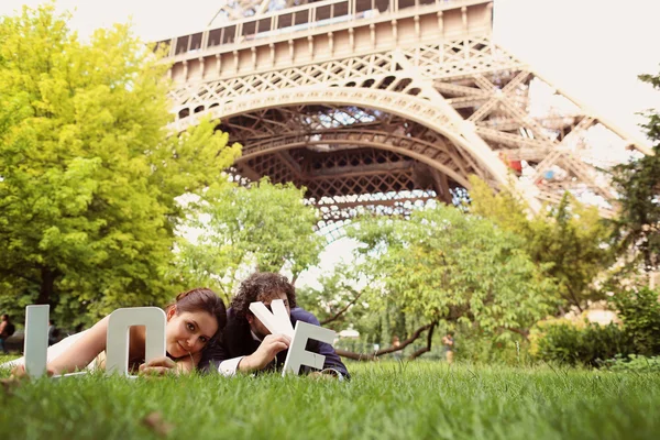 Novia y novio sosteniendo Hago cartas en su mano cerca de la torre Eiffel —  Fotos de Stock