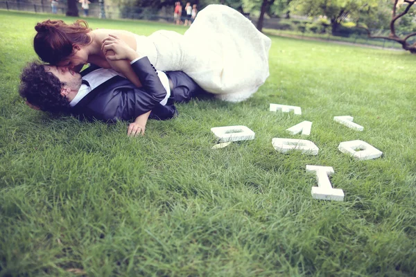 Nevěsta a ženich objímání v parku — Stock fotografie