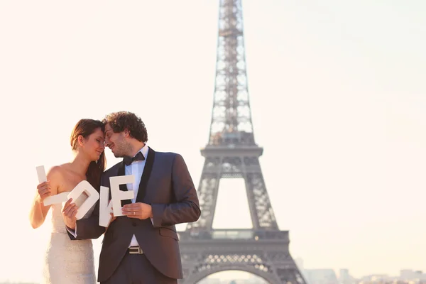 Mariée et marié tenant des lettres d'AMOUR dans leur main à Paris, France — Photo