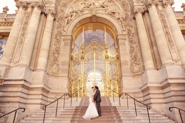 Жених и невеста перед большим зданием — стоковое фото