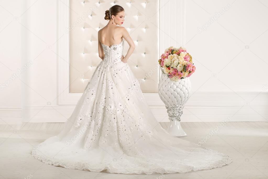 Gorgeous bride with white dress with flowers bouquet