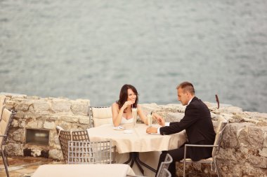 Gelin ve damat deniz yanındaki masada oturan