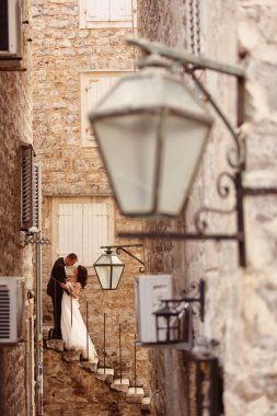 Gelin ve damat eski şehirde merdivenlerde öpüşme