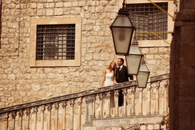 Gelin ve damat eski şehirde merdivenlerde öpüşme