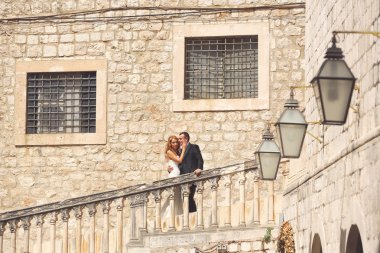 Gelin ve damat eski şehirde merdivenlerde öpüşme