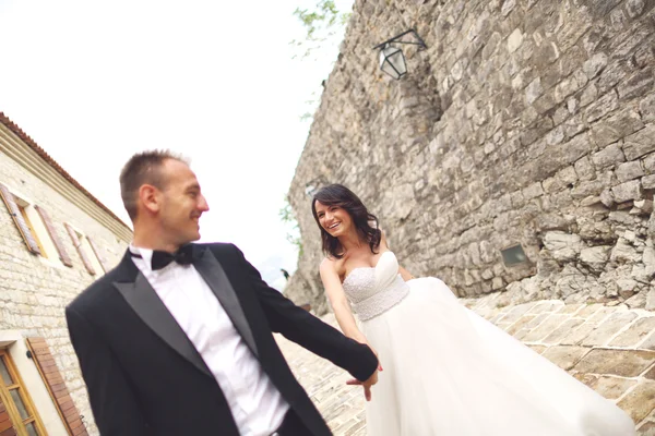 Happy bride and groom holding hands — Stock Photo, Image