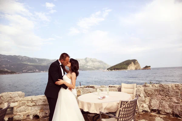 Noiva e noivo se beijando à beira-mar — Fotografia de Stock