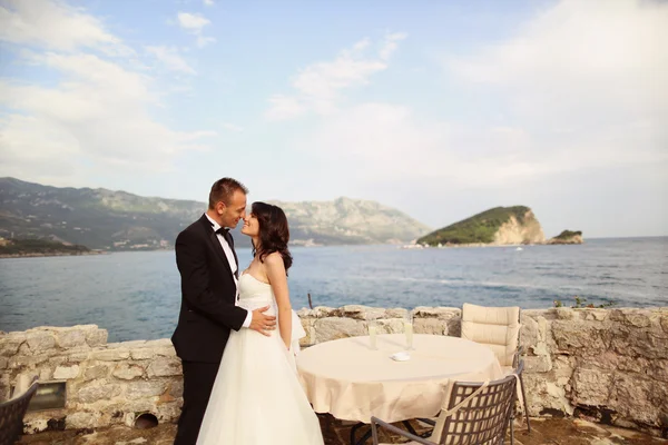 Bride and groom next to table at the seaside — Stock Photo, Image