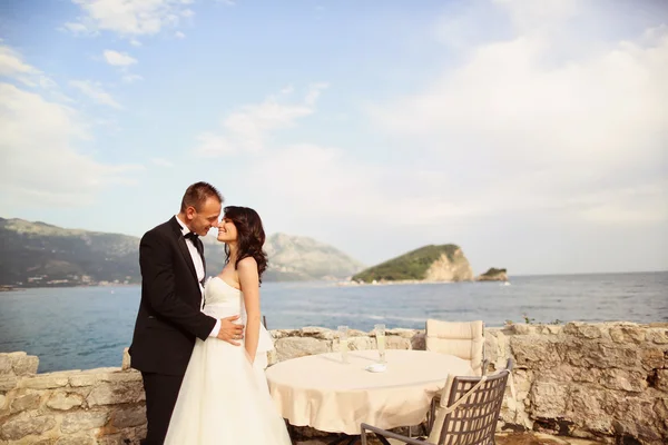 Braut und Bräutigam halten sich am Meer — Stockfoto