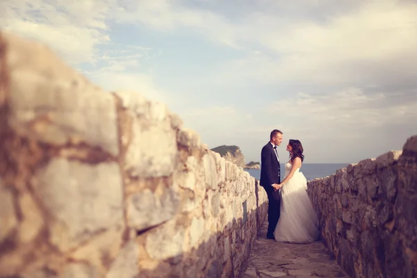 Bride and groom in stone pathway — Stock Photo, Image