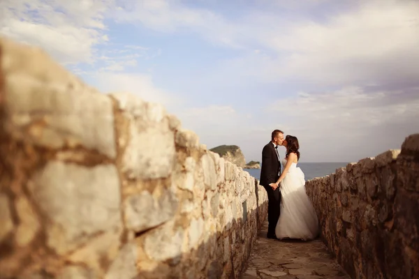 Novia y novio besándose en camino de piedra —  Fotos de Stock