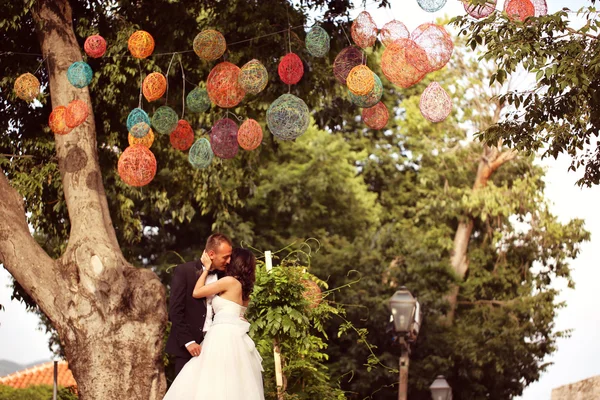 新郎和新娘接吻多彩的灯光下 — 图库照片