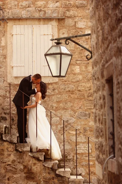 Bride and groom on stairs in old city — Stock Photo, Image