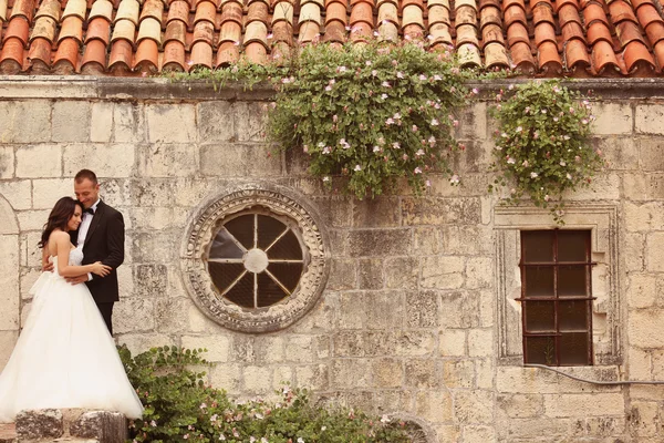 Sposa e sposo posa vicino alla vecchia casa — Foto Stock