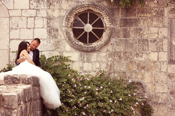 Bride and groom posing near old house — Stock Photo, Image