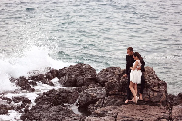 Novia y novio en las rocas en el mar —  Fotos de Stock