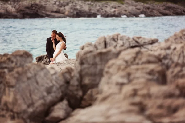 Nevěsta a ženich na skále u moře — Stock fotografie