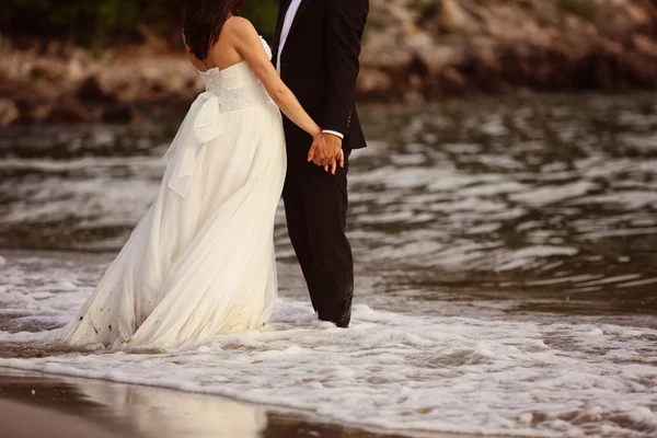 新娘和新郎手牵着手在沙滩上 — 图库照片