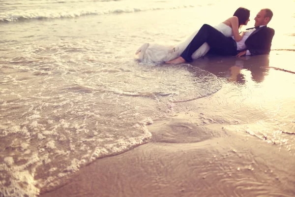 Noiva e noivo deitado na praia — Fotografia de Stock