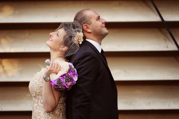 Mariée et marié à côté du mur dépouillé — Photo