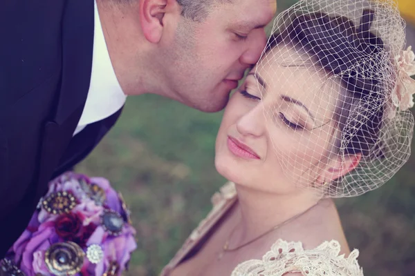 Noivo beijando sua noiva — Fotografia de Stock