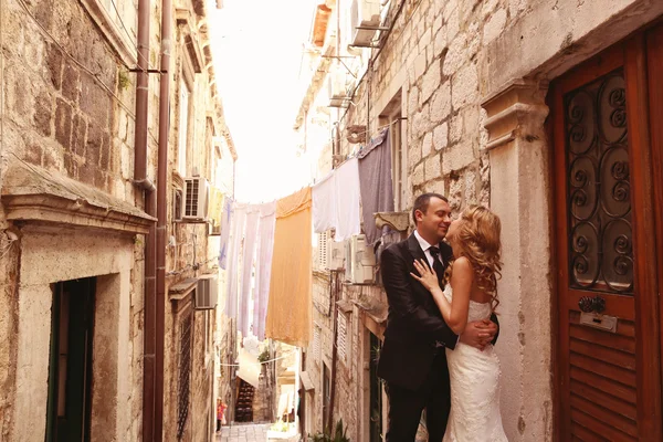 Наречений і наречений цілуються на сходах у старому місті — стокове фото