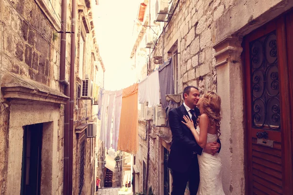 Bride and groom kissing on stairs in old city — Stock Photo, Image