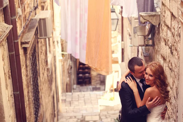 Жених и невеста целуются на лестнице в старом городе — стоковое фото