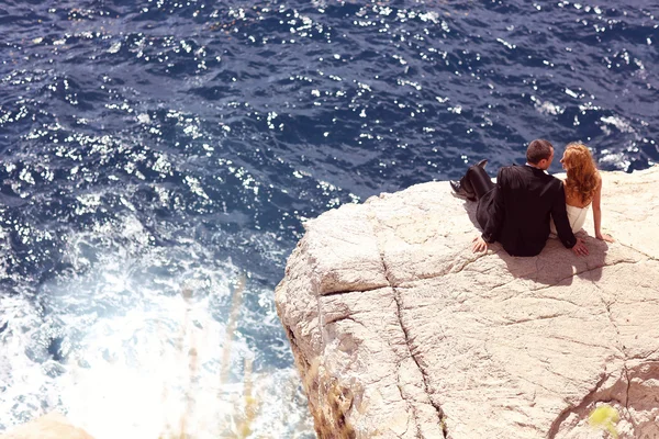 Bride and groom on cliff near seaside — Stock Photo, Image