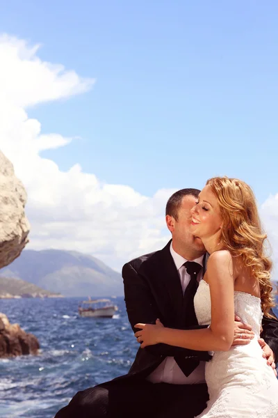 Groom kissing his bride at the seaside — Stock Photo, Image