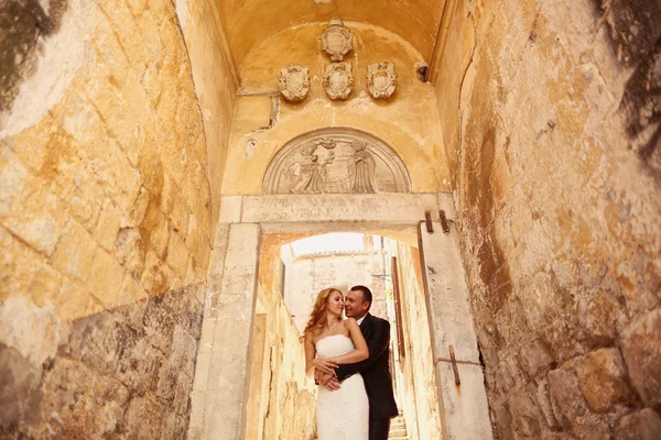 Groom holding his bride in vintage staircase — Stock Photo, Image