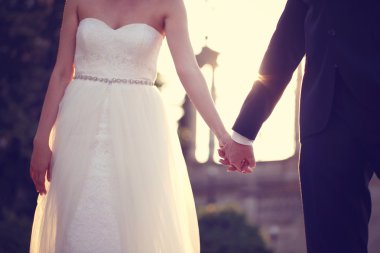 Gelin ve damat el ele tutuşuyorlar.